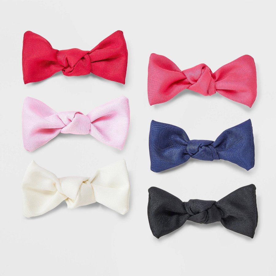 Six bow hair clips in assorted colors on a white background
